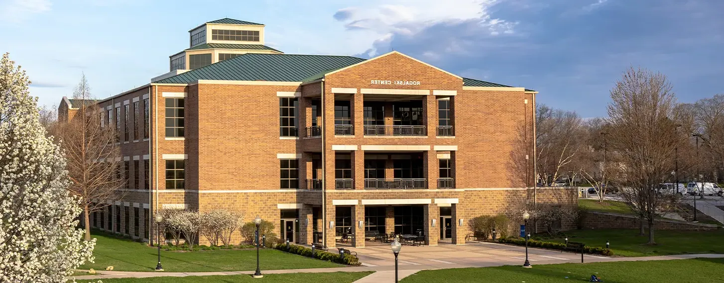 The St. Ambrose Rogalski Center featuring a tree in full bloom.